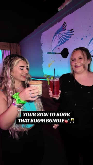A fast-paced, energetic video showcasing a visit to Boom Battle Bar. The creator and friends are seen playing various games like darts, axe throwing, and shuffleboard, while also enjoying cocktails and bar food including pizza, fries, and burgers. The video highlights the 'Boom Bundle' offer, providing a clear overview of the experience and value.