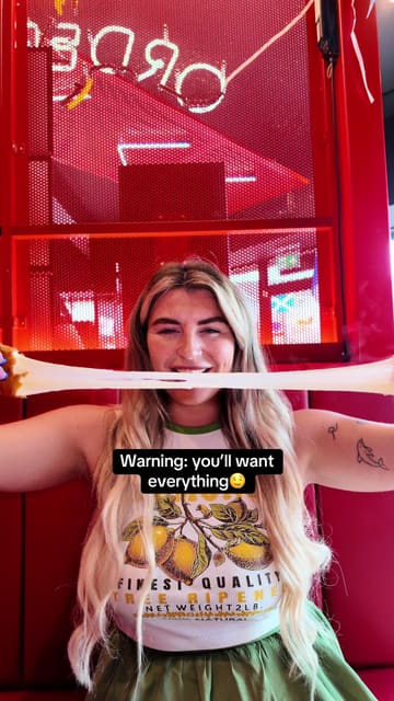 A fast-paced, vlog-style review of Lucky B's Hot Chicken in Glasgow. The creator and her friend sample a variety of items including cheese sticks, chicken tenders, burgers, loaded fries, and milkshakes, highlighting the customizable heat levels and the fun, casual atmosphere of the restaurant.