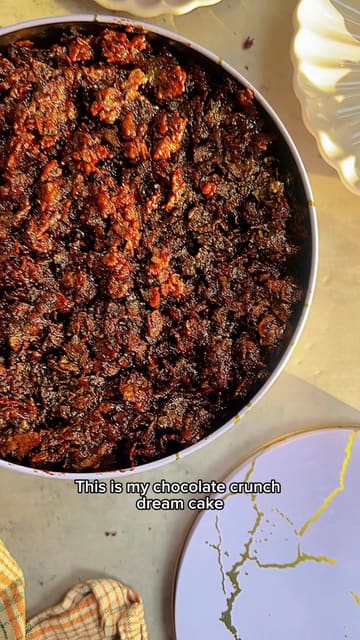 A clear and visually appealing recipe tutorial for a chocolate crunch dream cake, demonstrating the preparation of the sponge, mousse layer, and cornflake topping.