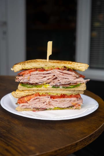 A fast-paced montage showcasing a variety of sandwiches from GNHM in Sketty, South Wales, highlighting the preparation and presentation of their menu items.