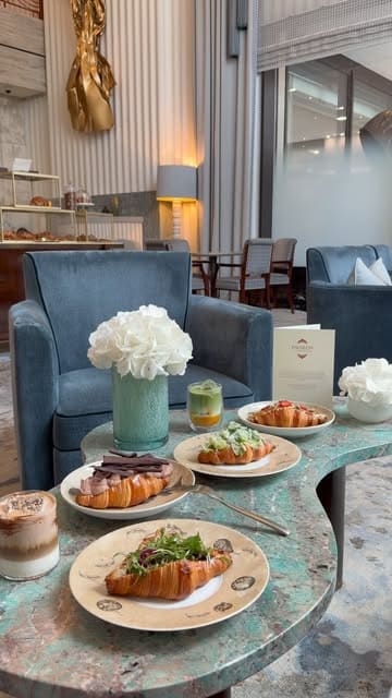 A high-quality, aesthetic montage showcasing a selection of gourmet croissants and a layered matcha drink at La Croissanterie within the Four Seasons Hotel London at Park Lane. The video features slow, deliberate camera movements focusing on the textures and presentation of the food, set against the backdrop of an elegant, upscale lounge.