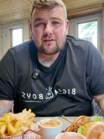 A creator reviews a new double smash burger special at The Devonshire Arms, highlighting the ingredients and offering a discount code for bookings.