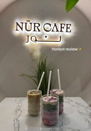 A vlog-style review of Nür Cafe in Manchester, featuring a tour of the aesthetic interior, a taste test of a berry matcha latte, and a critique of the English breakfast and beef melt toastie.