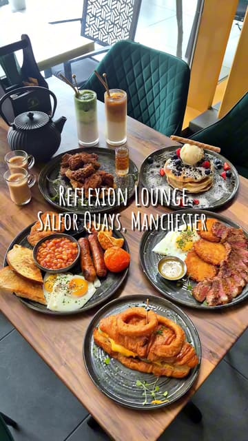 A montage showcasing the brunch menu and interior of Reflexion Lounge in Salford Quays, Manchester, featuring various dishes like pancakes, steak and eggs, and a croissant burger, alongside drinks and waterside views.