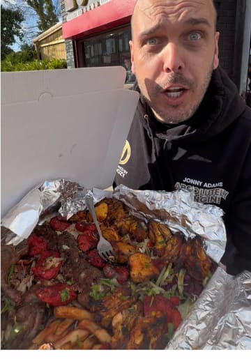 A high-energy food review of a large 'munchbox' takeaway from Ranya Shawarma Grill, featuring a variety of grilled meats, chips, and sides.