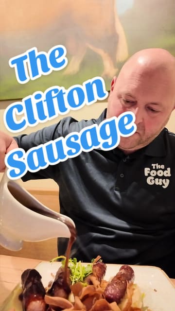 A couple visits The Clifton Sausage in Bristol, reviewing various dishes including Cornish mussels, crispy spicy cauliflower, a sausage tasting plate, and slow-roasted pork belly, while providing commentary on the atmosphere and service.