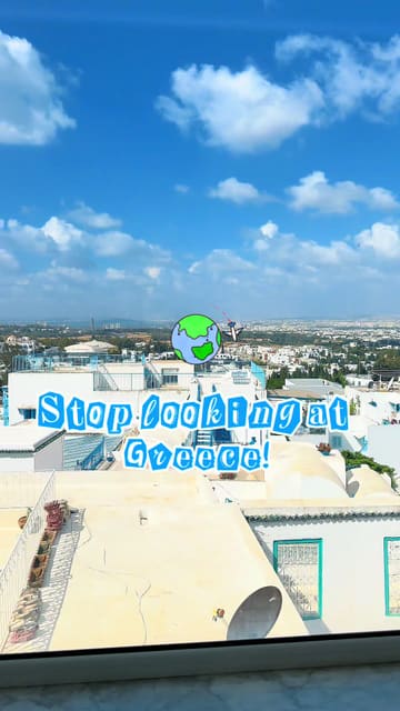 A travel-focused reel showcasing the picturesque blue and white architecture of Sidi Bou Said, Tunisia, presenting it as an alternative to Greece. The video features shots of the streets, a hotel property with a pool, and a breakfast or brunch spread.