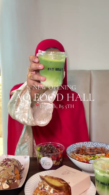 A montage-style video showcasing a visit to the new AQ Food Hall, highlighting various dishes from different vendors including pastries, acai bowls, matcha drinks, and noodle dishes.