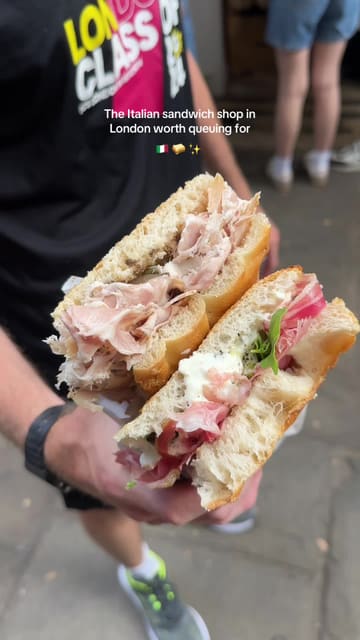 A short, punchy video showcasing Via Romana Deli in London, highlighting the queue, the deli counter, the meat slicing process, and the final sandwiches.