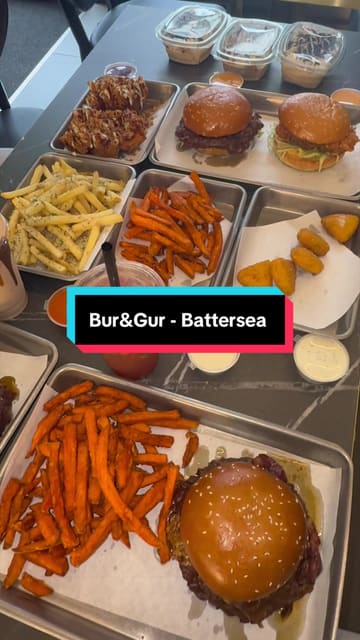 A review-style video featuring two creators visiting a new burger venue in Battersea. The video includes shots of the exterior, the kitchen preparation process, and the creators tasting various items including smash burgers, chicken tenders, and fries. The tone is enthusiastic and conversational, focusing on the quality of the food.