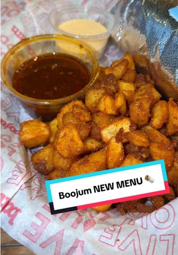 A creator reviews new menu additions at Boojum, specifically highlighting the burrito and potato cubes, while providing commentary on the flavours and combinations.