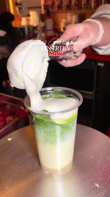 A short, punchy video showcasing the menu at Mello, a marshmallow dessert bar located in Seven Dials Market. The video features close-up shots of iced matcha drinks topped with whipped marshmallow crème and fresh strawberries, highlighting the preparation process and the final product.