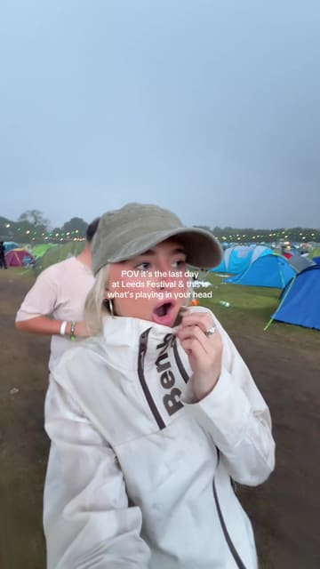 A short, handheld vlog-style clip capturing the experience of walking through a muddy campsite at Leeds Festival during a thunderstorm.
