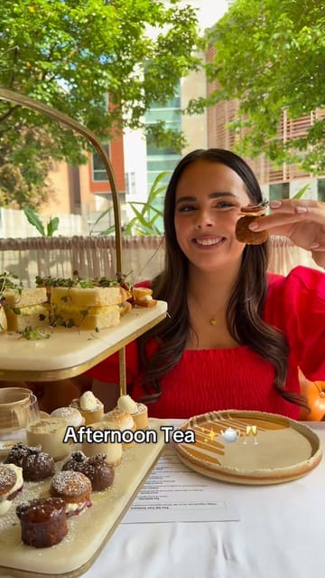The video features two creators reviewing an afternoon tea experience at 'Tea On The Terrace' in Dublin. It showcases the venue's interior and terrace, the variety of savoury and sweet items in the afternoon tea set, and the creators' reactions to the food.