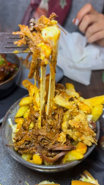 A review of The Balgriffin Inn in Dublin, featuring a variety of pub food including loaded fries, buffalo wings, a steak sandwich, and a chicken burger, alongside a pint of Guinness.