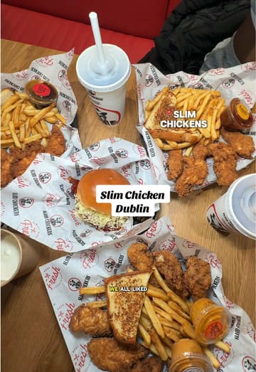 A vlog-style review of a new Slim Chickens location in Dundrum Shopping Centre, Dublin. The creator shows the exterior, the ordering kiosk, the interior, and a spread of their meal, including chicken tenders, fries, Texas toast, and various sauces.