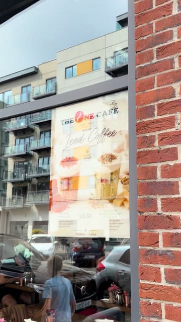 A casual review of The One Cafe, showcasing the menu, an iced coffee, and the Giggs Benedict dish.