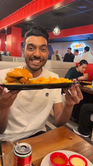 A creator visits Jimmy's Killer Prawns in Manchester, reviewing a variety of dishes including halloumi sticks, calamari, a prawn burger, and a seafood platter.