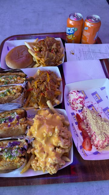 A food influencer reviews the new menu at NYK Fried Chicken, featuring sandos, loaded fries, a handcrafted cheeseburger, and a berry dessert. The video consists of the creator sitting at a table, describing and tasting each item.