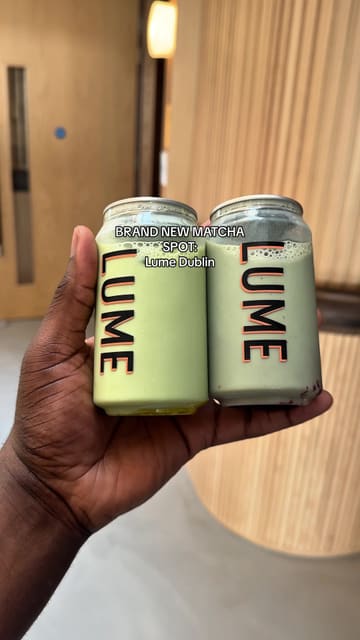 A creator showcases a new brand of canned matcha drinks called 'Lume', demonstrating the product, tasting it, and sharing it with others at an event space.