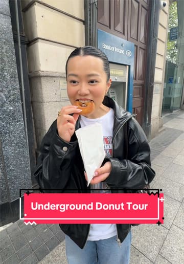 A creator and her partner participate in a guided walking donut tour in Dublin, visiting multiple shops including The Rolling Donut, Sweet Churro, and Offbeat. The video features the creator talking to the camera, showing the donuts, and highlighting the tour guide's knowledge of Irish history.