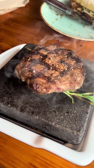 A short review of The Grill Shack in Kildare, featuring close-up shots of loaded fries, nachos, steak on a hot stone, and chicken wings. The creator provides a voiceover commentary on the food quality.
