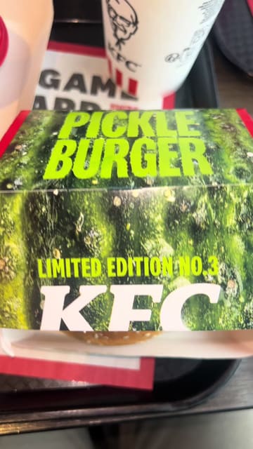 A short, punchy review of the limited-edition KFC Pickle Burger and Pickle Fries. The creator documents the ordering process at the kiosk, the wait time, and provides a candid taste test of the burger, chicken tenders, and fries with gravy.