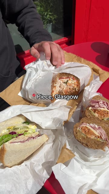A short, punchy review of Piece in Glasgow, showcasing their large, freshly made sandwiches including the Chicken Ole, Cubano, and Reuben. The video features quick cuts of the food, the menu board, and the shop exterior.