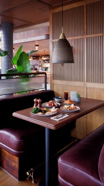 A high-quality, aesthetic video showcasing the interior, riverside views, and breakfast menu at Coppa Club London Bridge. The footage features smooth pans of the dining area and close-ups of brunch dishes like poached eggs with salmon, french toast, and coffee.
