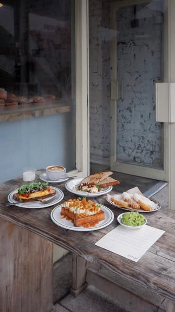 A montage of brunch dishes and coffee at a cafe, featuring French toast, eggs, and pastries.