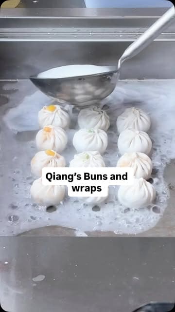 A video showcasing the preparation and serving of handmade dumplings, wraps, and fried buns at Qiang's Bun & Wrap in Chinatown, highlighting the affordability and variety of the menu.