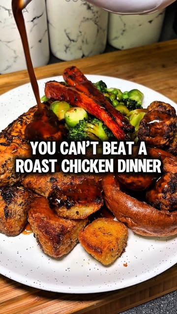 A home cooking video demonstrating how to prepare a simplified Sunday roast dinner, featuring chicken breast, honey-roasted carrots, crispy potatoes, and sausage stuffing balls.