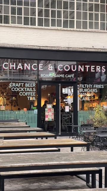 A short video showcasing Chance & Counters, a board game cafe. The footage includes the exterior, the extensive library of board games, a child playing a game, and close-ups of the food and drink menu and served items like burgers and loaded fries.
