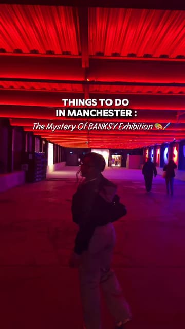 A vlog-style tour of the 'Mystery of Banksy' exhibition in Manchester, showcasing various art installations and the immersive nature of the experience, with a brief mention of a nearby food venue.