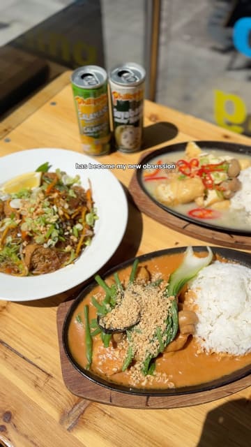 A short video review showcasing three Filipino dishes at a restaurant in Bristol. The video features close-up shots of sizzling plates and noodles, with text overlays describing the food.