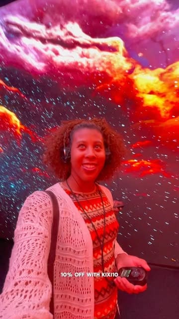 A selfie taken inside the 'TIMEWALK' immersive exhibition at Immerse LDN, featuring a vibrant, colourful digital projection background.