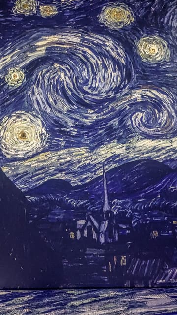 A montage of various Van Gogh paintings projected onto the walls and floors of an immersive exhibition space. The video cycles through different famous works, showcasing the scale and atmosphere of the installation.