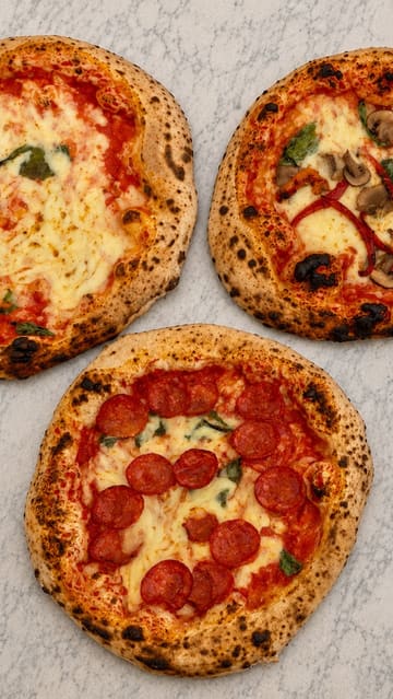 A short, engaging video showcasing the process of making Neapolitan-style pizza at a backyard pop-up venue. It follows the journey from the alleyway entrance to the dough preparation, baking in a portable oven, and the final product.