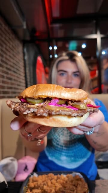 A creator visits the newly opened Kongz in Edinburgh, showcasing a variety of their menu items including mozzarella sticks, loaded fries, a burger, pizza, and milkshakes.