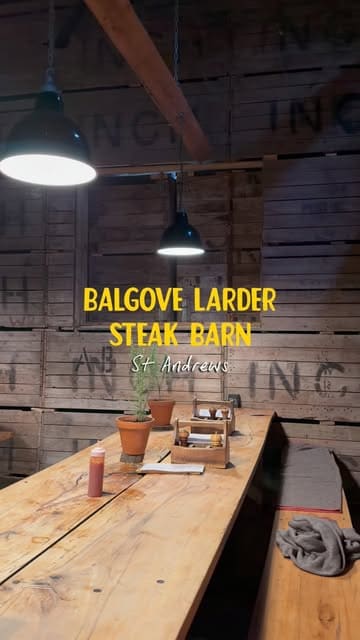 A montage video showcasing the Balgove Larder Steak Barn in St Andrews, featuring shots of the exterior, the rustic interior, the open fire grill, and various dishes including steak, burgers, and dessert.