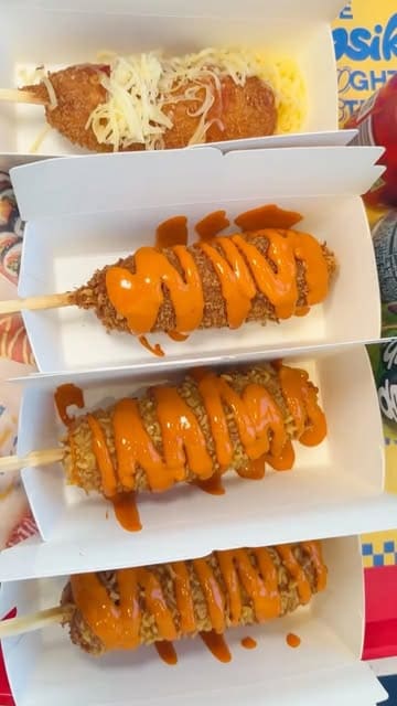 A fast-paced, music-driven reel showcasing a variety of Korean street food dishes at Bunsik, including corndogs, tteokbokki, and fried chicken, alongside glimpses of the venue's atmosphere.