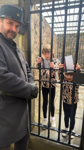 A family visits Inveraray Jail, exploring the historical prison exhibits, interacting with costumed characters, and touring the cells and courtroom.