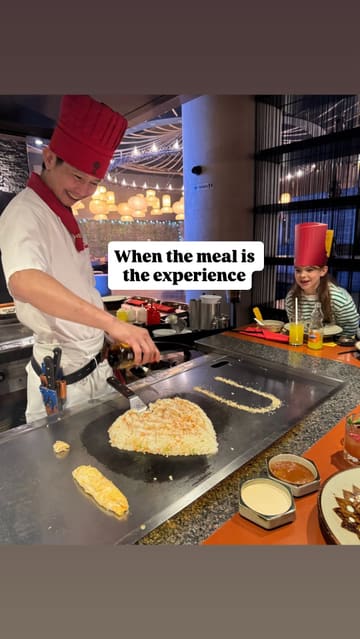 A short, energetic video capturing the interactive teppanyaki cooking experience at Benihana. The footage focuses on the chef's knife skills, fire tricks, and egg juggling, while also showing children enjoying the performance. The video effectively communicates the fun, family-friendly atmosphere of the venue.