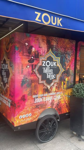 A review of the Sunday Roast experience at Zouk Tea Bar & Grill in Manchester, featuring a variety of dishes including samosa chaat, spiced halloumi pakora, a roast platter with chicken, beef, and lamb, and desserts like chai masala brulee and pistachio souffle.