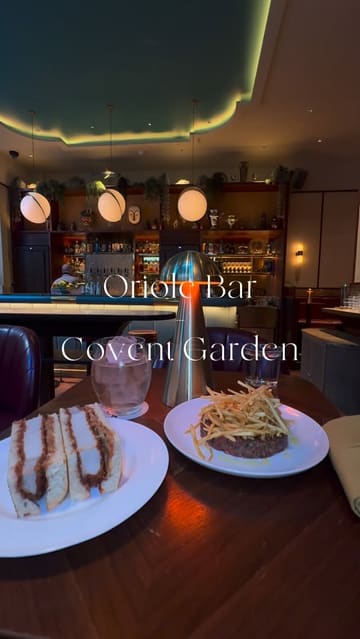 A short, polished video tour of Oriole Bar in Covent Garden, featuring close-ups of cocktail preparation, the venue's interior, and food items like pork katsu sando and steak tartare.