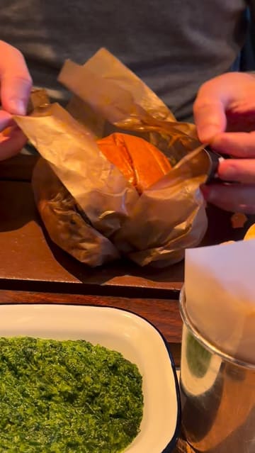 A short, punchy review of a visit to Flat Iron, featuring close-ups of their smashed onion double cheeseburger, sides like creamed spinach and mac and cheese, drinks, and their signature soft-serve ice cream.