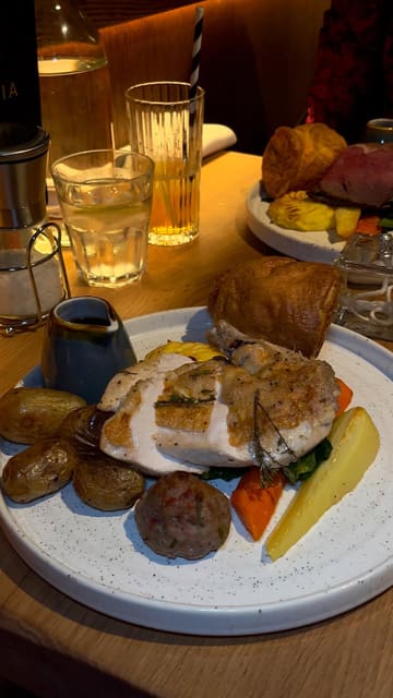 The video features a series of shots showcasing a Sunday roast meal at La Storia in Nottingham. It includes close-ups of the roast beef, gravy being poured, garlic bread, and a dessert, along with brief shots of the restaurant interior and menu.