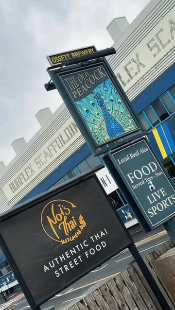 A short, energetic video showcasing The Old Peacock pub in Leeds, which hosts Noi's Thai Kitchen. The video features a tour of the pub's interior, close-ups of various Thai dishes, and a focus on the local beer collaboration with Ossett Brewery.