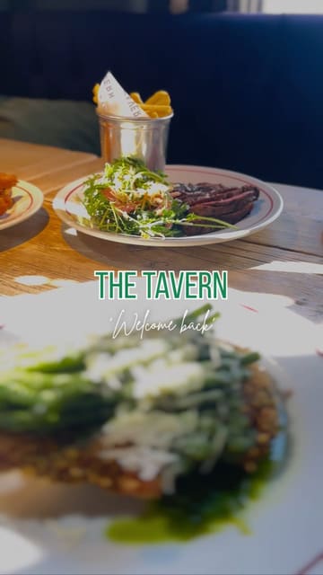 A short montage showcasing a few dishes, including steak with fries and green beans, served at a venue called The Tavern. The video focuses entirely on the food presentation with music and a simple text overlay.