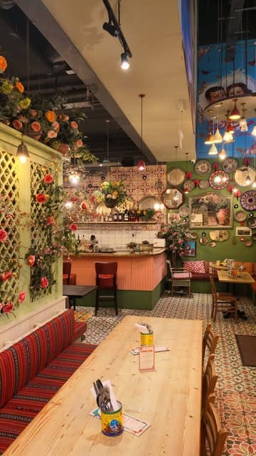 A promotional video for Comptoir Libanais in Spinningfields, Manchester, featuring shots of the restaurant's vibrant interior decor and a variety of Lebanese dishes including hummus, skewers, and salads.